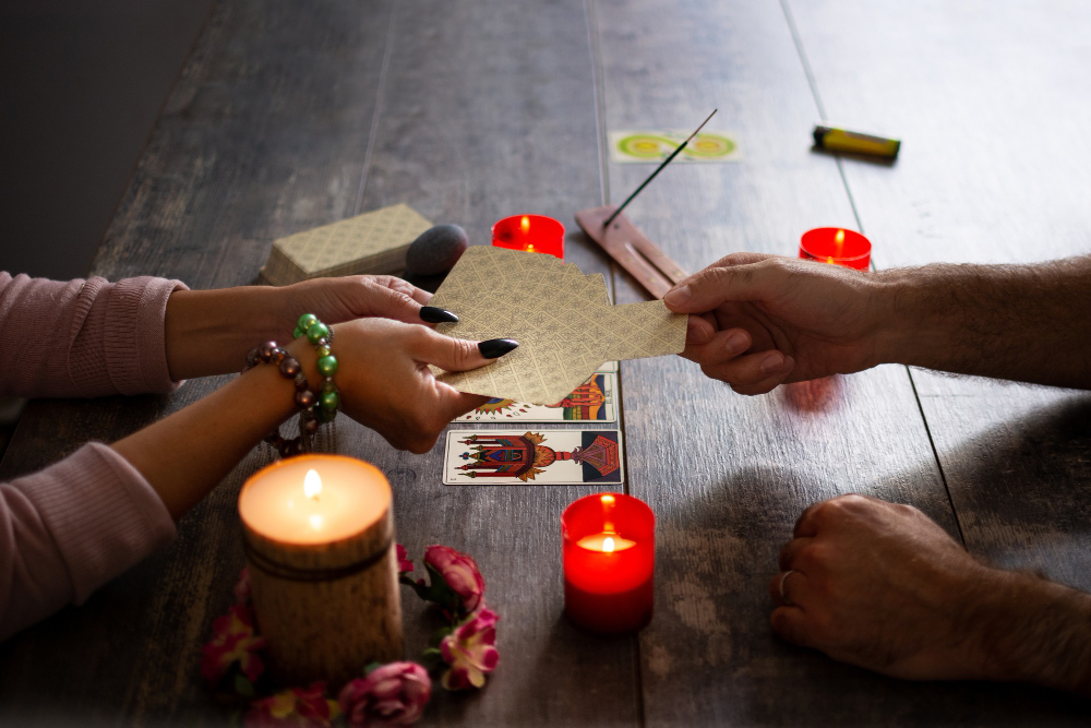Cărțile de tarot așezate pe masă, între lumânări aprinse, la o consultație